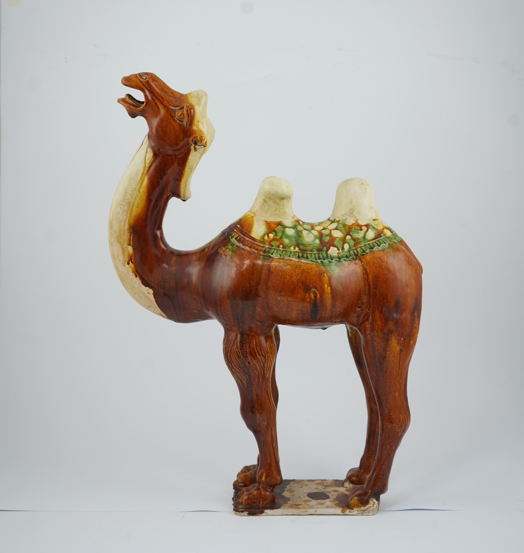 A large Chinese sancai pottery figure of a bactrian camel, Tang dynasty